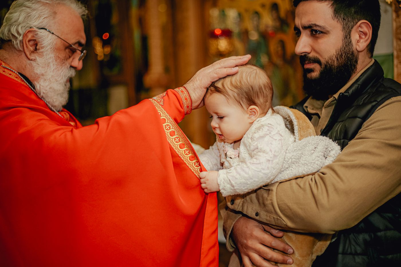 A priest blessing a baby during Baptism